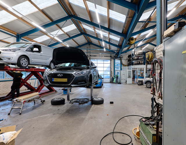 Hyundai op de brug met een monteur aan het werk in de werkplaats